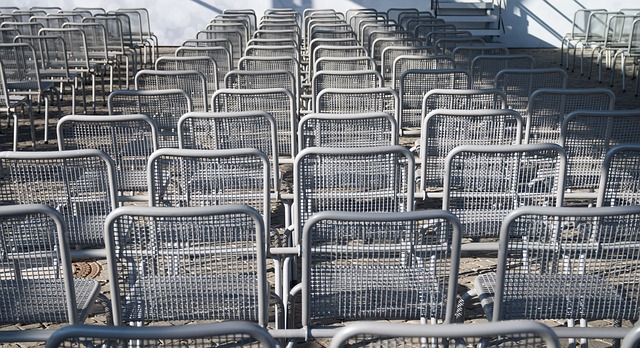 Steel-made chairs line up next to each other, Image by Michael Kauer from Pixabay